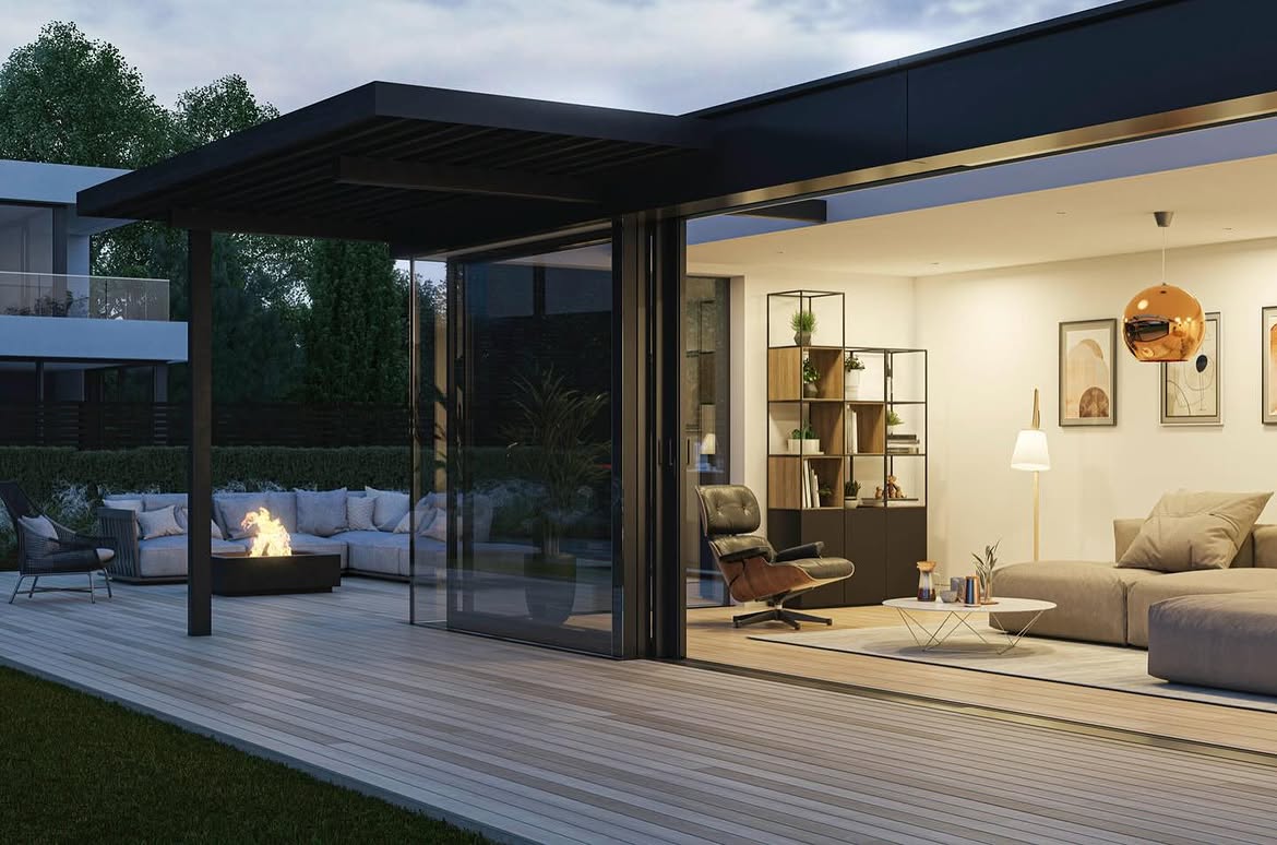 Salón abierto a un porche con chimenea exterior al anochecer