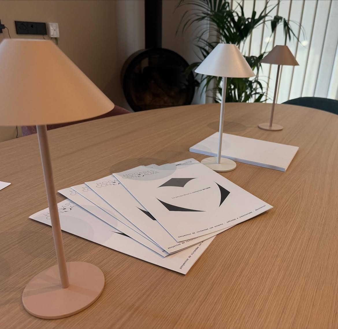 Folletos de Hogares con Alma sobre la mesa del showroom del estudio